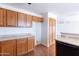 Kitchen view featuring wood cabinets, sleek countertops, black appliances, and a pantry adjacent to the breakfast bar at 1361 W Roosevelt Ave, Coolidge, AZ 85128