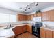 Kitchen with wood cabinets, black appliances, stylish track lighting, and ample counter space at 1361 W Roosevelt Ave, Coolidge, AZ 85128