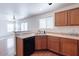 Kitchen space with wood cabinets, and a view into the living area beyond the breakfast bar at 1361 W Roosevelt Ave, Coolidge, AZ 85128