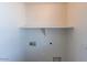 Laundry room with shelf and utility hookups, offering convenience and functionality at 1361 W Roosevelt Ave, Coolidge, AZ 85128