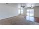 Bright living room features neutral carpet, ceiling fan, and sliding glass doors to the backyard at 1361 W Roosevelt Ave, Coolidge, AZ 85128