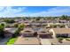 An aerial view showcases this home with solar panels in a neighborhood with mature trees under a blue sky at 13834 N 39Th Ln, Phoenix, AZ 85053