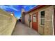 View along side of home showcasing a brick facade, red door and a chimney at 13834 N 39Th Ln, Phoenix, AZ 85053