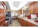 Well-lit kitchen featuring wood cabinetry, stainless steel appliances, granite countertops, and a view into the dining area at 13834 N 39Th Ln, Phoenix, AZ 85053