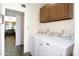 Well-lit laundry room has a washer, dryer, tiled flooring, and built-in cabinets at 13834 N 39Th Ln, Phoenix, AZ 85053