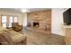 Inviting living room with a brick fireplace, wood-look tile floor and comfortable, neutral-toned furniture at 13834 N 39Th Ln, Phoenix, AZ 85053