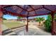 View from beneath pergola overlooking lawn, stone landscaping, and home exterior at 13834 N 39Th Ln, Phoenix, AZ 85053