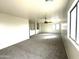 Large living room with carpet floors, ceiling fan, and natural light from large window at 1492 S 218Th Ln, Buckeye, AZ 85326