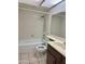 Full bathroom with a shower-tub combo, wood vanity and a white tiled backsplash at 1512 N Iowa St, Chandler, AZ 85225