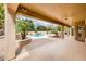 Inviting backyard featuring a covered patio, lush landscaping, and a sparkling pool at 17218 W Mahogany Way, Surprise, AZ 85387