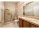 Bright bathroom featuring a tiled shower, vanity with solid surface counter, sink and a mirrored wall at 17218 W Mahogany Way, Surprise, AZ 85387