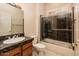 Bathroom featuring a vanity with solid surface counter, sink and a tiled shower with glass doors at 17218 W Mahogany Way, Surprise, AZ 85387