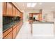 Eat-in kitchen featuring stainless steel appliances, green granite countertops, and tile flooring at 17218 W Mahogany Way, Surprise, AZ 85387