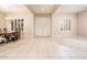 Spacious and bright living room featuring tile flooring, carpet accents, and elegant double doors at 17218 W Mahogany Way, Surprise, AZ 85387