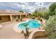 Relaxing backyard with a sparkling pool, rock water feature, and lush landscaping for ultimate privacy at 17218 W Mahogany Way, Surprise, AZ 85387