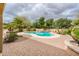 Private pool area featuring lush landscaping, a rock waterfall, and a spacious brick patio at 17218 W Mahogany Way, Surprise, AZ 85387