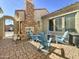 Private courtyard with brick pavers, a stone fireplace, and comfortable seating under string lights at 17346 W Lincoln St, Goodyear, AZ 85338