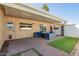 Covered backyard with paved stone flooring, blue patio furniture, and a synthetic grass accent at 2112 E Minton Dr, Tempe, AZ 85282