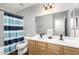 Bright bathroom featuring a dual sink vanity, large mirror, and stylish blue striped shower curtain at 21740 W Sonora St, Buckeye, AZ 85326