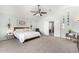 Spacious main bedroom featuring carpet floors, ceiling fan, ensuite bathroom with double doors and decorative accents at 21740 W Sonora St, Buckeye, AZ 85326