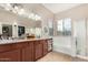 A bright bathroom featuring double sinks, granite counters, a large mirror, and a tub at 22319 E Via De Olivos --, Queen Creek, AZ 85142