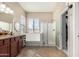 Bright bathroom featuring a large tub, shower, and dark wood vanity with granite countertop, offering a serene and modern space at 22319 E Via De Olivos --, Queen Creek, AZ 85142