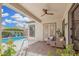 Inviting covered patio with brick accents, ceiling fan, and comfortable seating overlooks a sparkling pool at 22319 E Via De Olivos --, Queen Creek, AZ 85142