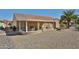 Exterior view showcasing the covered patio area, complete with seating and a lush backyard landscape at 23106 N 146Th Ln, Sun City West, AZ 85375