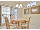 Cozy dining area featuring a wooden table and chairs, with a sliding glass door for outdoor access at 23106 N 146Th Ln, Sun City West, AZ 85375