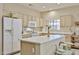 Well-lit kitchen features an island, white cabinets, and white appliances at 23106 N 146Th Ln, Sun City West, AZ 85375