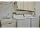 Practical laundry room with white cabinets, sink, washer, and dryer, providing convenience at 23106 N 146Th Ln, Sun City West, AZ 85375