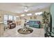 Inviting living room featuring a leather sofa, ceiling fan, tile floors, and natural light from multiple windows at 23106 N 146Th Ln, Sun City West, AZ 85375