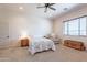 This is a cozy bedroom features a ceiling fan, window with blinds, and a comfortable armchair at 2349 W Skyline Ln, San Tan Valley, AZ 85144