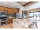 Kitchen with granite counters, stainless appliances, wood cabinets, and a dining area at 2349 W Skyline Ln, San Tan Valley, AZ 85144