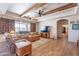 Spacious living room with wood beams, wood-style floors, barn door shutters, and comfortable seating at 2349 W Skyline Ln, San Tan Valley, AZ 85144