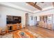 Living room with wood-style floors, wood beams, entertainment center, and an open floor plan at 2349 W Skyline Ln, San Tan Valley, AZ 85144