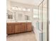 Bathroom featuring double sink vanity, large mirror, soaking tub, and separate shower with glass doors at 2530 W Gaby Rd, Phoenix, AZ 85041