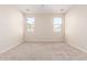 Carpeted bedroom featuring two bright windows and neutral walls at 2530 W Gaby Rd, Phoenix, AZ 85041