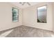 A simple bedroom featuring two windows and neutral carpeting at 2530 W Gaby Rd, Phoenix, AZ 85041