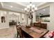 This dining room has warm wood furniture, stylish lighting, and a view into the adjacent living spaces at 3110 E Cat Balue Dr, Phoenix, AZ 85050