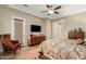 Comfortable main bedroom featuring wood floors, ceiling fan and flatscreen television at 3110 E Cat Balue Dr, Phoenix, AZ 85050