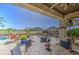 Spacious backyard with a covered patio, pool, and outdoor kitchen, perfect for entertaining and enjoying the outdoors at 32241 N Dog Leg Ct, San Tan Valley, AZ 85143