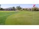 Beautiful green golf course with a flag waving in the wind and houses in the background at 32241 N Dog Leg Ct, San Tan Valley, AZ 85143