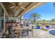 Inviting outdoor patio with built-in bar, dining area, and views of a sparkling pool and lush landscaping at 32241 N Dog Leg Ct, San Tan Valley, AZ 85143