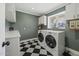 Functional laundry room with modern appliances and classic black and white tile flooring at 325 E Aepli Dr, Tempe, AZ 85282