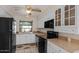 Bright kitchen with white cabinets, black appliances, laminate countertops, and a ceiling fan at 3309 N 70Th St # 108, Scottsdale, AZ 85251