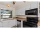 Bright kitchen featuring white cabinets, black appliances and laminate countertops, and a view to the patio at 3309 N 70Th St # 108, Scottsdale, AZ 85251