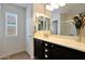 Bathroom with a large mirror over a single sink vanity, complemented by a window for natural light at 3519 S 185Th Dr, Goodyear, AZ 85338