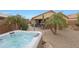 Inviting backyard oasis with a rejuvenating hot tub, lush tropical palms, and a paver patio at 3519 S 185Th Dr, Goodyear, AZ 85338