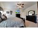 Spacious main bedroom with a ceiling fan, TV, and dark wood furniture for ample storage and comfortable living at 3519 S 185Th Dr, Goodyear, AZ 85338